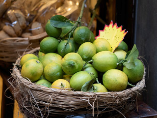 Basket with green lemons on a wooden table
