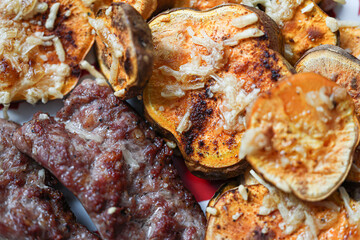 Plato de batatas asadas con queso gratinado y chorizo, resaltando texturas y colores cálidos. Ideal para quienes disfrutan de comidas reconfortantes y sabrosas.