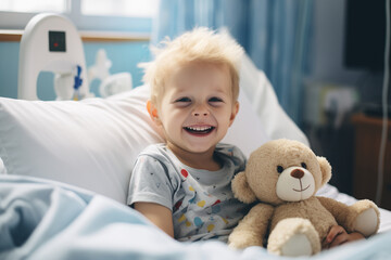 Small child resting on a hospital bed in the pediatric ward, accompanied by a comforting teddy bear