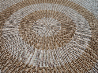Naklejka premium Circle shaped rugs are woven from jute or natural fibers. Large handmade floor rugs are woven from white and brown rope. Bent jute rope rug 