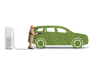 Woman charging an electric vehicle made of green grass