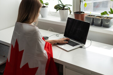 Young female student with Canadian flag and laptop with space for text