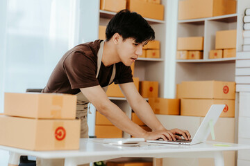 SME small business entrepreneur, young Asian freelancer working at home with boxes Use smartphones...