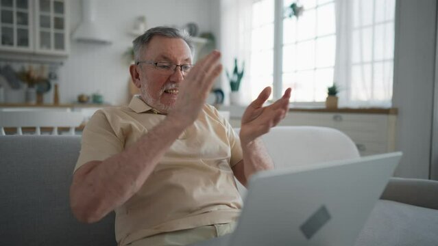 One man senior caucasian male with beard sit home in day with laptop computer making online purchase shopping buy stuff hold credit card pensioner enjoy his retirement. Older man with technology.