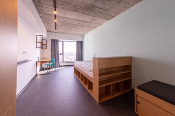 Simple student-style dorm bedroom. Hostel dormitory room. Campus