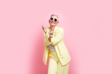 Photo businesswoman in yellow suit dancing after conference where she has promoted to team lead position isolated on pink color background