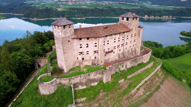most famous and beautiful medieval castles of northern Italy. scenic Cles castel- in Trentino , province of Trento. surrouded by fields of apple trees near the lake Santa Giustina