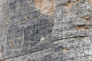 A rock climber climbing a vertical rock wall. Outdoor sports. Mountaineering lifestyle.