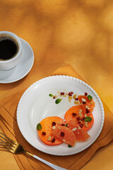 Healthy breakfast concept. Oatmeal, quinoa granola with yogurt, dried fruit, seeds, honey, persimmon in white plate on yellow background, top view, copy space. Allergy-friendly, gluten free concept