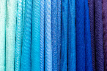 Multicolored folded fabric texture. Pile of bright folded fabric clothes.