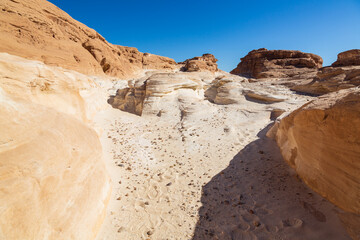 Sinai desert. Yellow and orange sandstone textured carved mountain, bright blue sky. Egyptian desert landscape. Sinai peninsula, Egypt