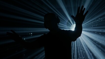 Silhouette of a DJ at Club Event with Stage Lights