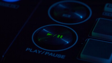 DJ Console Close-Up with Play and Pause Button Illuminated