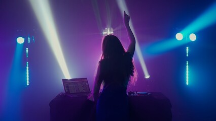 Fototapeta na wymiar Silhouette Female DJ Celebrating Music at Nightclub with Colorful Lights