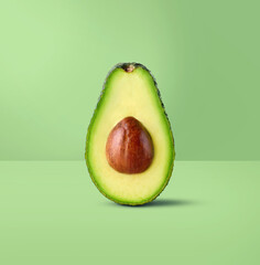 Half of fresh green avocado on pastel green background