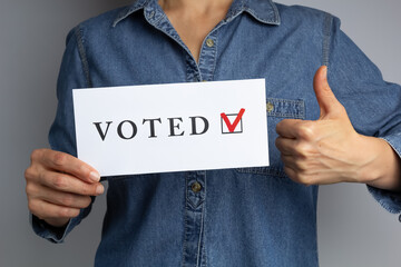 Thumbs up and voting sheet in woman's hand. Election concept. 