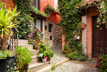 Narrow street of small town with many flowers in Italy