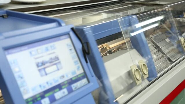 View of working knitting machine in workshop. A row of industrial textil flat knitting machines in a knitwear factory. Manufacture of knitwear, modern computerized flat Knitting Machine
