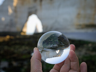 Chalk cliffs of Etretat seen through glass sphere