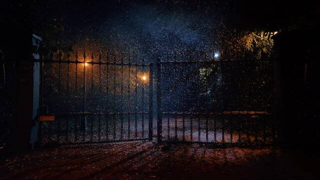 Cancello di ferro che sia apre nella notte sotto la neve