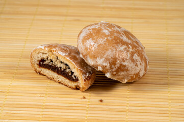 Gingerbread cookies with filling in sugar glaze on a light wooden background