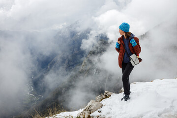 Woman Tourist Hiker Enjoying the View from the Summit of Conquered Mountain Already Covered by Snow...