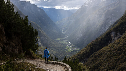 Hiker Enjoying Beautiful View on Alpine Valley from a Viewpoint With Raincoat on in Autumn Unstable...