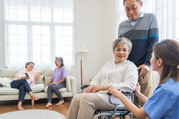 Fototapeta premium Asian young nurse support couple senior older man and woman in a wheelchair. elderly mature and a group of senior friends living in the hospital. socializing of retired people.