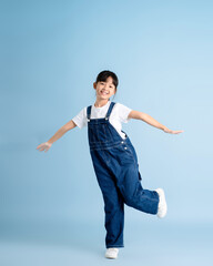 Fototapeta na wymiar Full body image of an Asian girl posing on a blue background