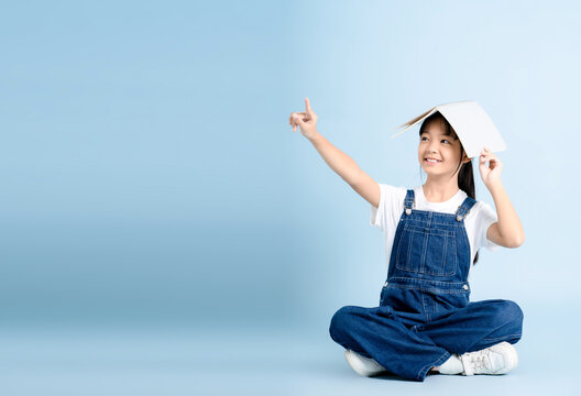 Image of an Asian girl studying and posing on a blue background