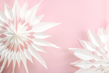 Traditional paper 3D snowflakes on pastel pink background. Winter handmade, DIY activity