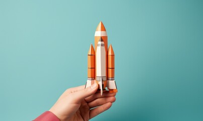 Hand holding a toy rocket, blue background, business and startup concept. Generative AI