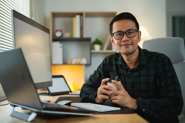 Smart Asian man smiling wearing glasses working with computer laptop. concept work form home, stay...