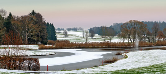 golf course at winter with pond, snow and water fountain in Bath Tatzmannsdorf in the region...
