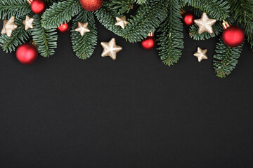 Christmas black background with fir tree, baubles and stars. Top view with copy space for your text