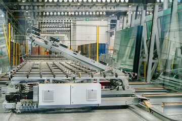 Interior of glass and mirror cutting factory. Interior view of a glazier factory with glass panels on trolleys awaiting cutting. Sheet glass in pallets.