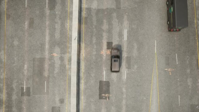 Cars and cloud shadows fly along a multi-lane concrete road with patched potholes. The camera is looking perpendicularly downward.