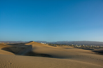 Fototapeta na wymiar Sand dunes of Maspalomas with a view of the city on Gran Canaria, Spain