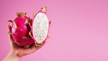 Foto op Plexiglas Hand holding sliced dragon fruit isolated on pastel background © Ari
