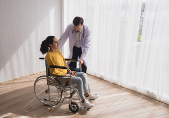 Portrait latin american woman sick sit wheelchair with man doctor caucasian sitting two people check and treat patients talk helping support explain medicine sick person inside hospital room service - obrazy, fototapety, plakaty