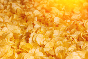 Fresh Crispy potato chips snack texture background with sun light, top view