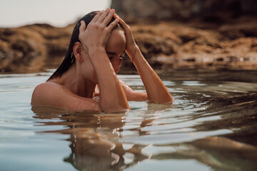 Portrait of wet woman with wet body in ocean water. Woman swim in ocean water