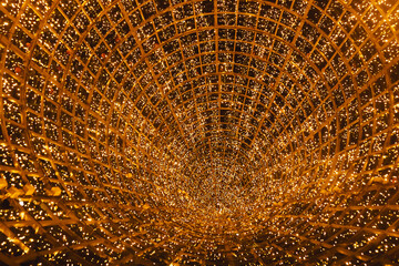 New Year's tree in the city of Lisbon. Christmas lights in Portugal. view inside the tree, orange and yellow glare garlands.
