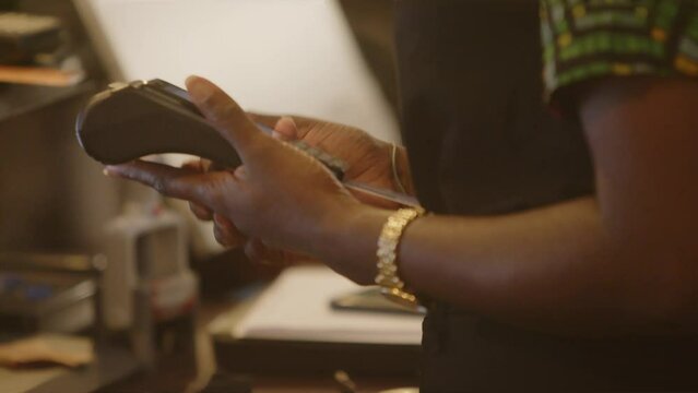 Hands of a black person using card payment