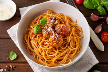 Traditional Italian spaghetti pasta with meatballs, tomato sauce and parmesan cheese, selective focus. Comfort food.