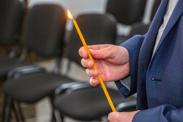 Church candle in the hands of a man close-up