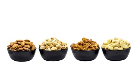 Almond Nut, Pistachio, Walnut and Cashew Nut Dried Fruits in Black Bowls Isolated on White Background in Horizontal Orientation, Healthy Eating and Lifestyle Food Concepts