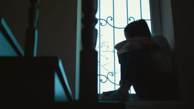 Pensive young woman with long hair resting at home