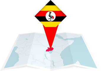Uganda pin flag and map on a folded map