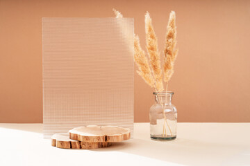 Podium for exhibitions and product presentations, material: glass, stone, wood, dry branches. Beautiful peach background made from natural materials. Abstract nature scene with composition.